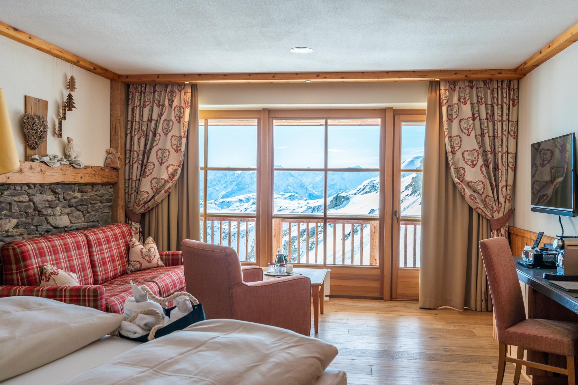 A cozy room with a view of the mountains. The decor is rustic and inviting, perfect for relaxing.
