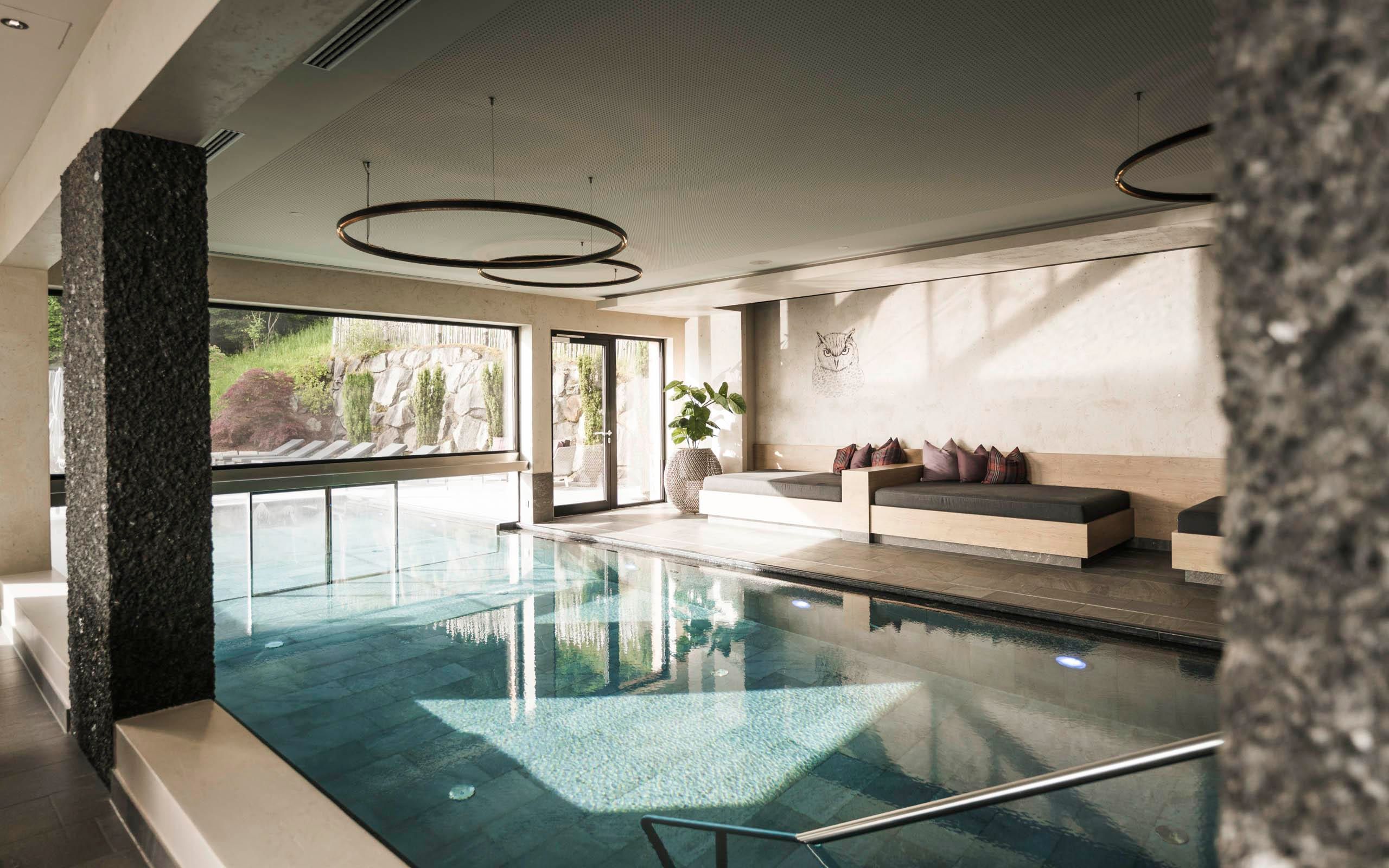 An elegant wellness area with an indoor pool and modern seating.
Large windows let in plenty of light and offer a view of the natural surroundings.