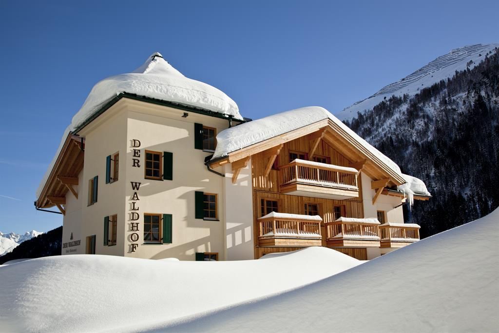 An elegant house in the snow with a distinctive roof. The surroundings are enveloped by a picturesque winter landscape.