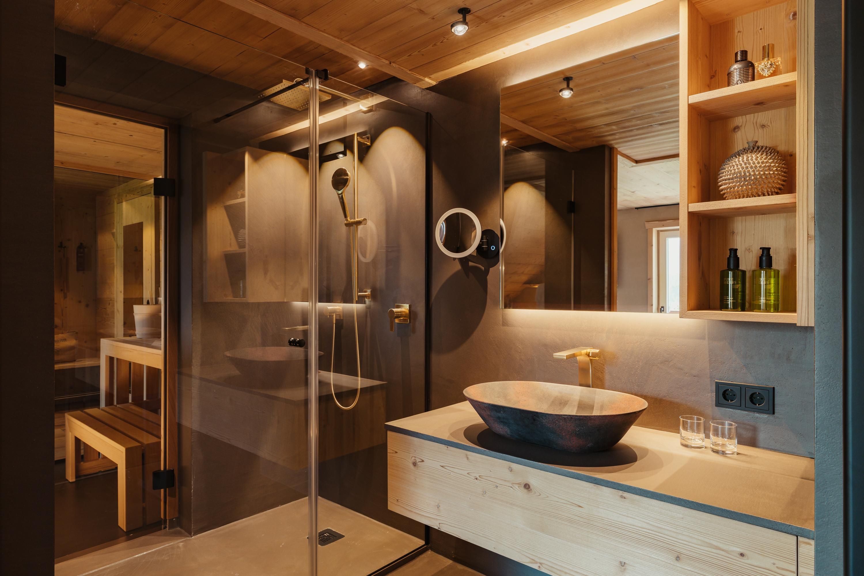 A modern bathroom with an elegant shower and a stylish sink. Wooden shelves provide toiletries and a pleasant atmosphere.