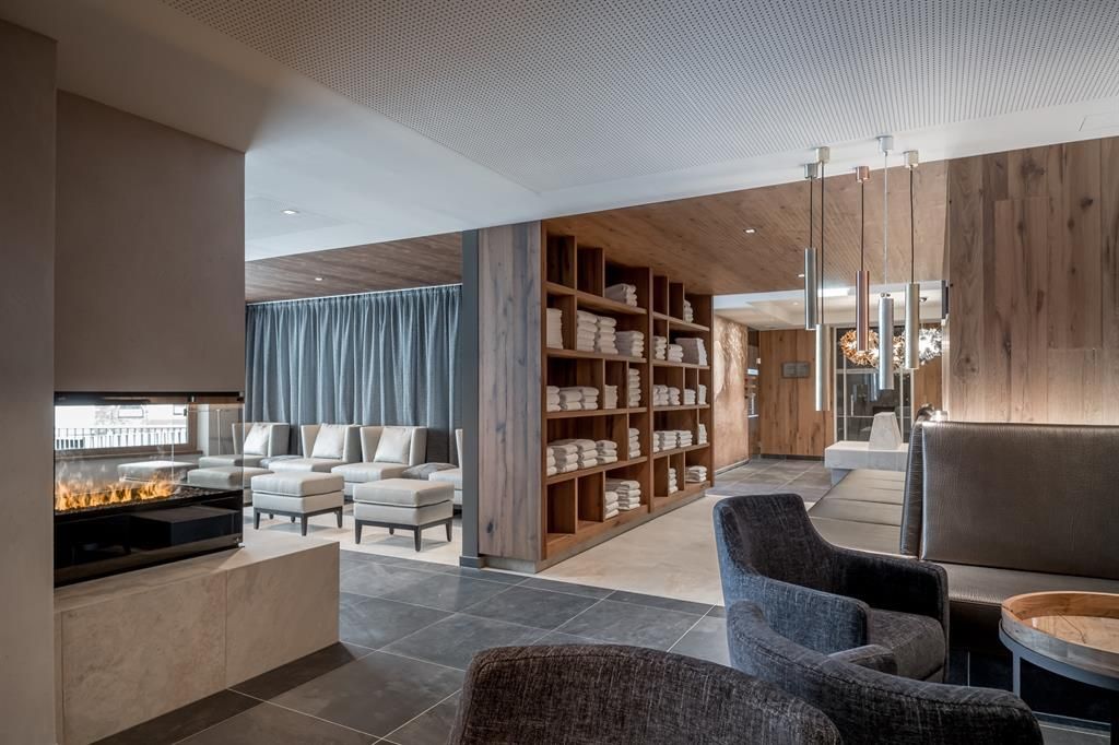 A modern reception area with comfortable armchairs and wooden shelves. The room exudes tranquility and elegance.