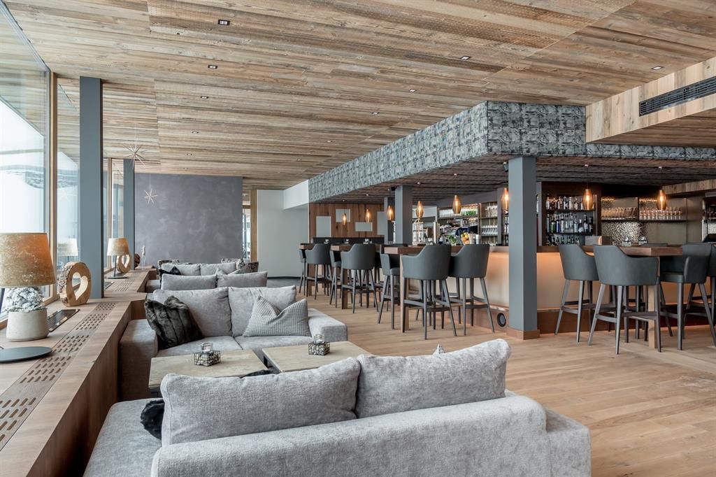 A modern lounge with comfortable sofas and a stylish bar area.
Bright wood elements and large windows create an inviting atmosphere.