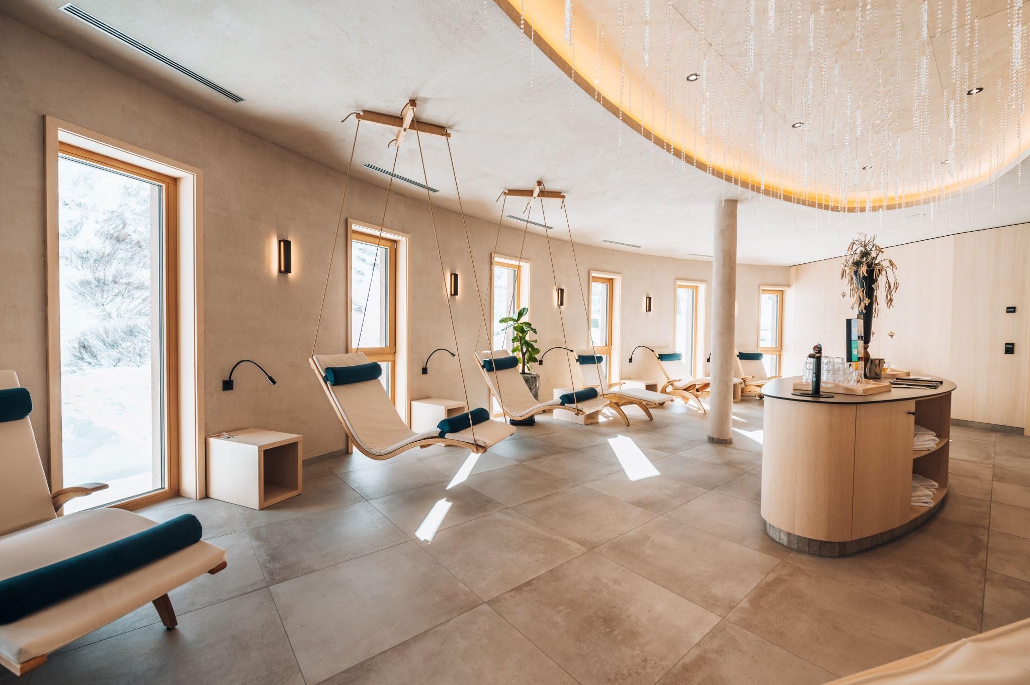 A modern wellness area with comfortable loungers and soft lighting. Large windows provide plenty of daylight and a relaxing atmosphere.