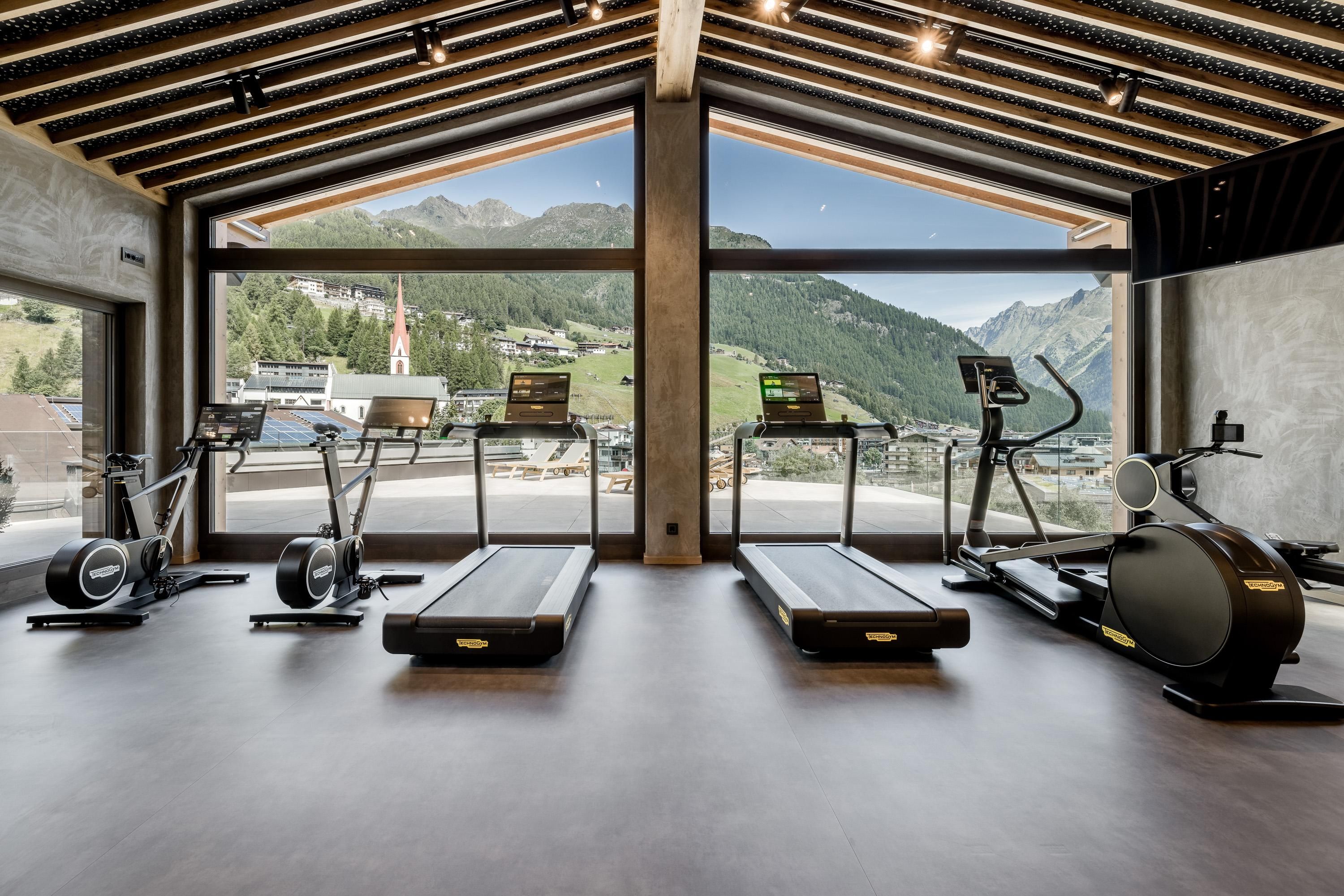 A modern gym with a view of the mountains. Several training devices are available to enable an effective workout.