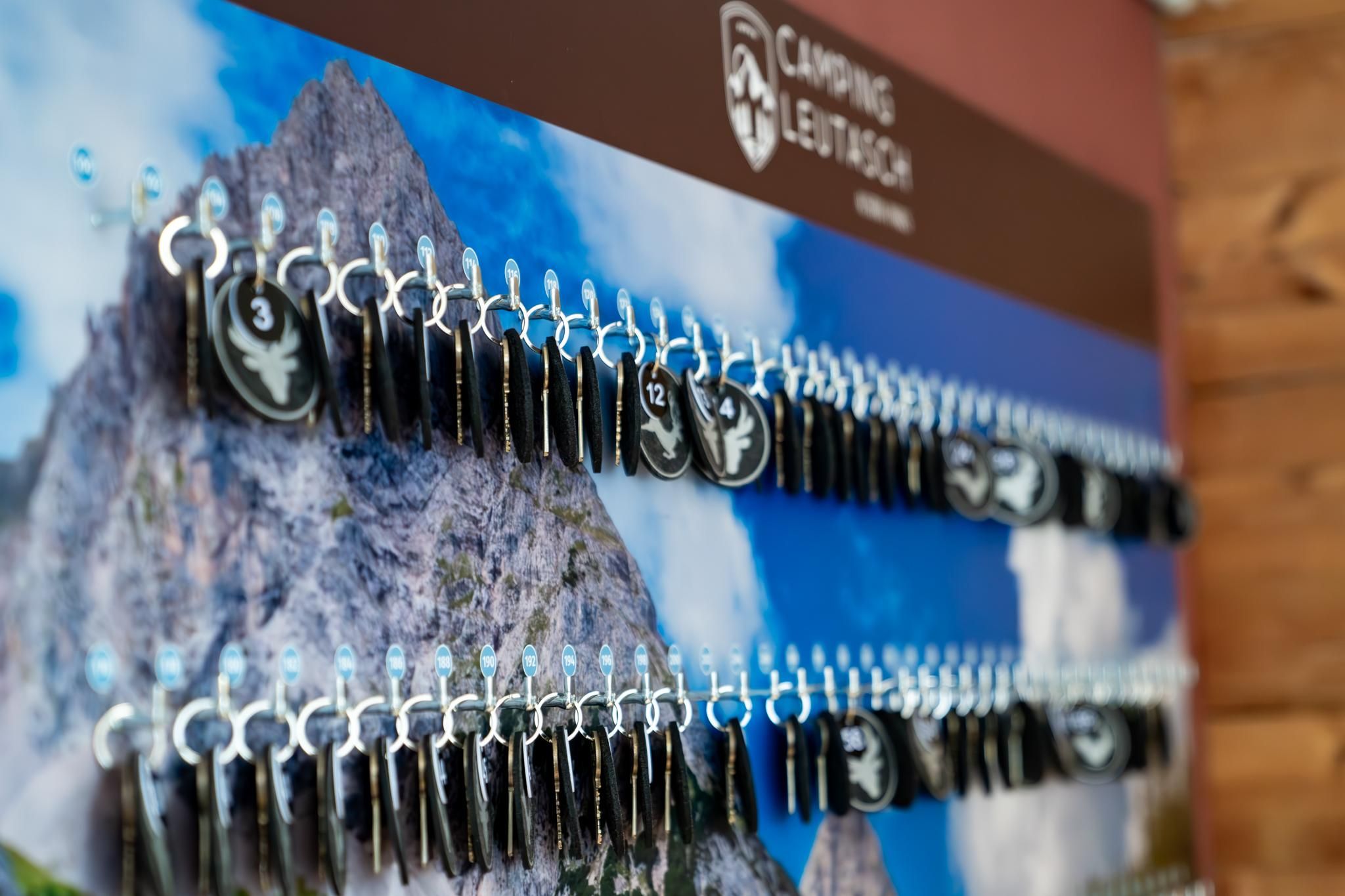 A wall with many keys for campsites. In the background, there is an image of a mountain.