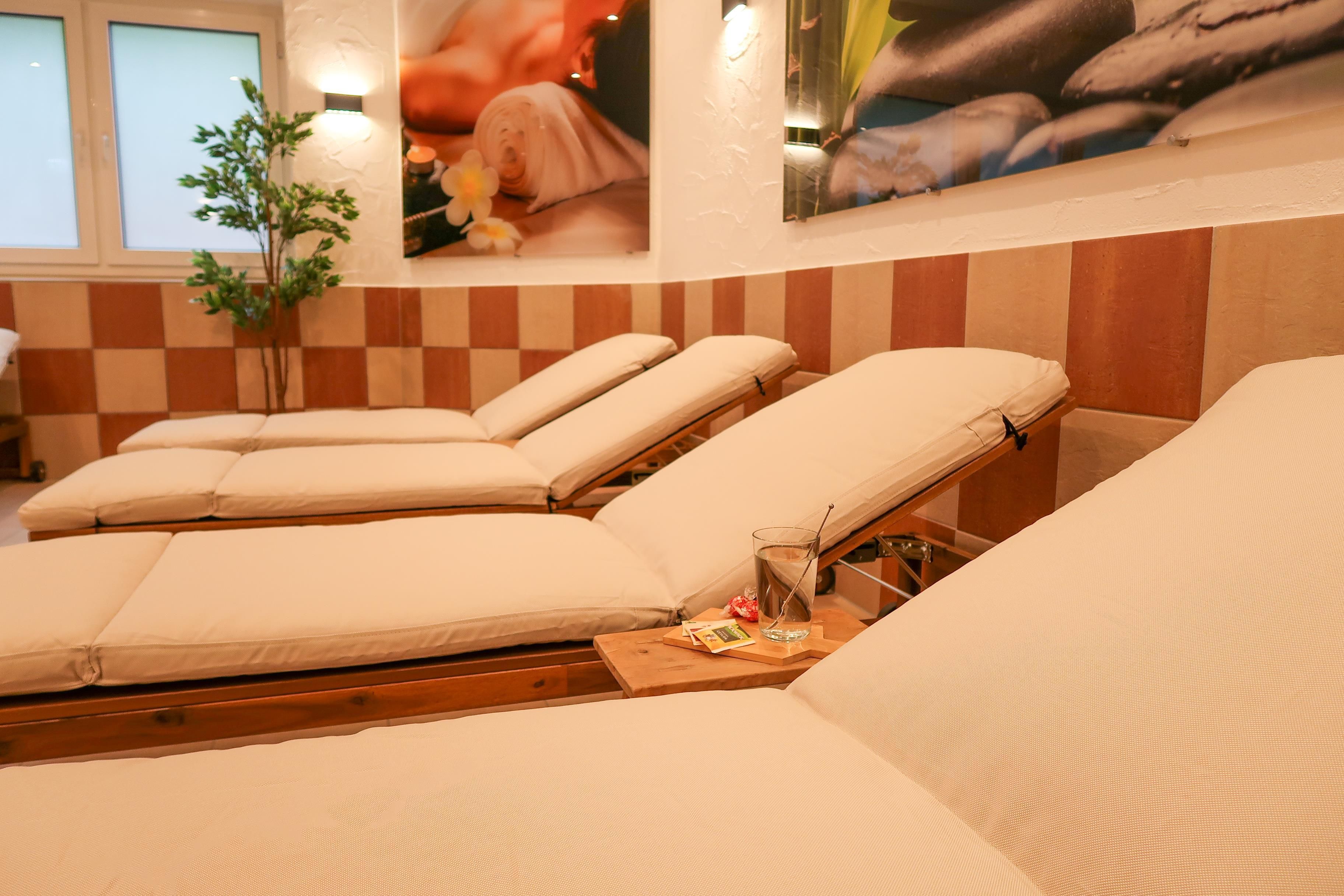 A relaxing wellness area with loungers and soothing wall pictures. The atmosphere is cozy and inviting.