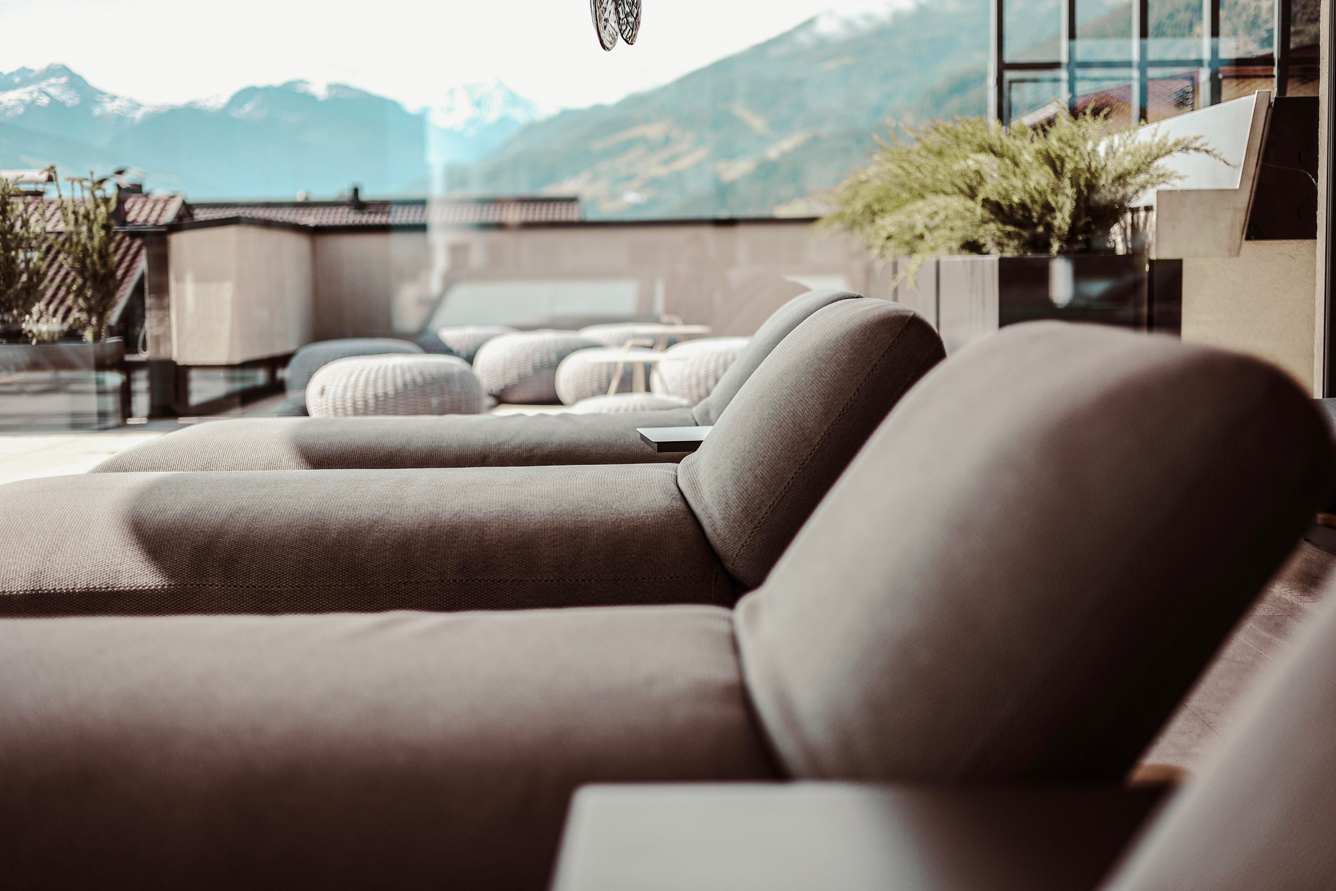 Relaxed loungers on a terrace with a view of the mountains. The atmosphere is modern and welcoming.
