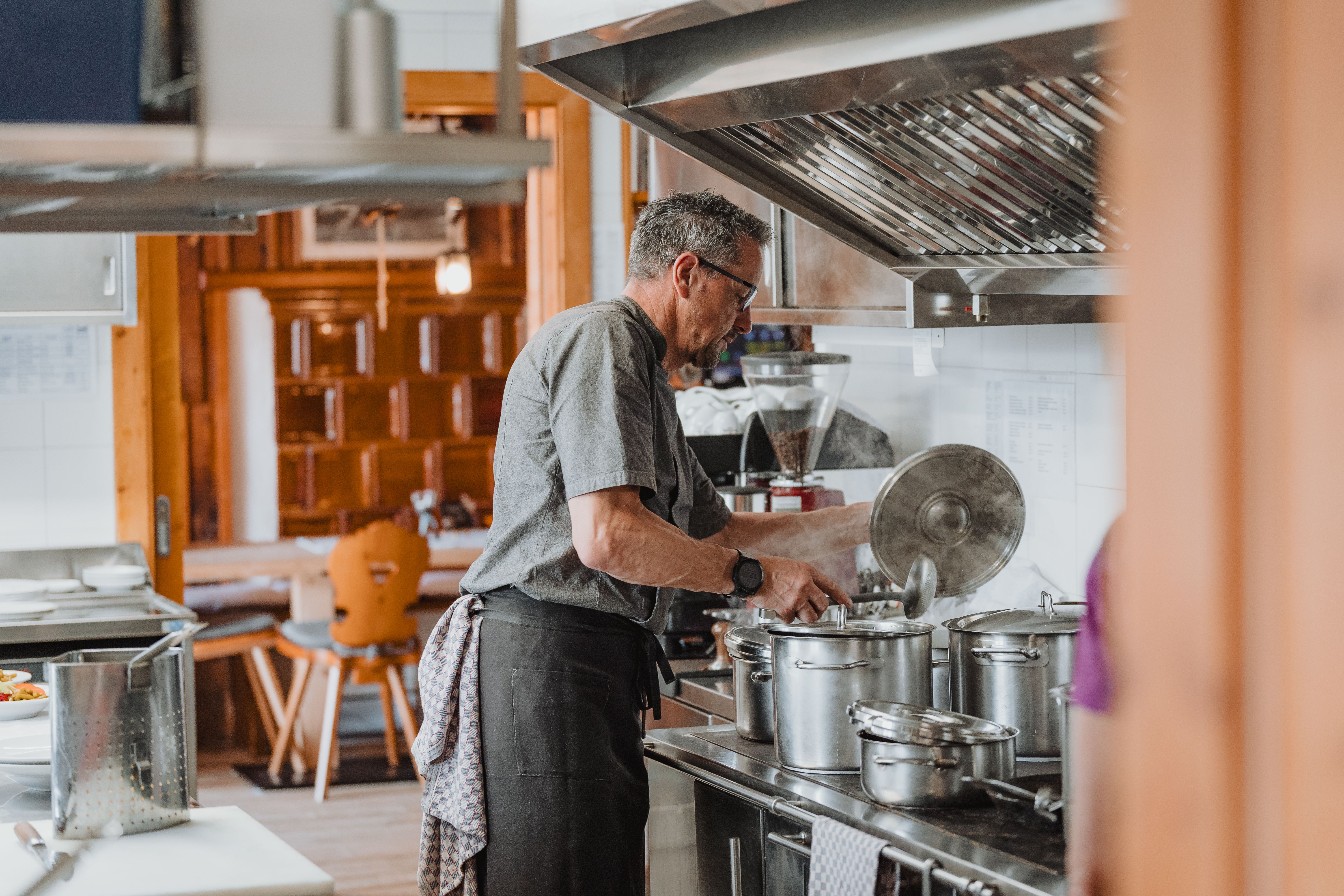 Küche der Geraer Hütte, Wirt kocht am Herd