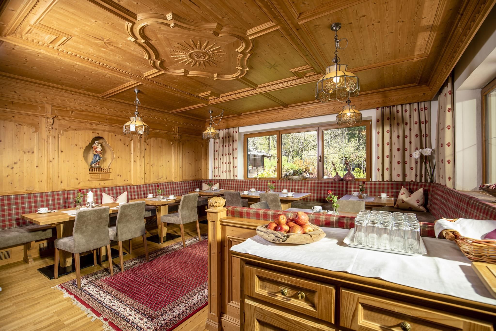 A cozy dining room with paneling and warm light. The tables are friendly set and invite you to linger.