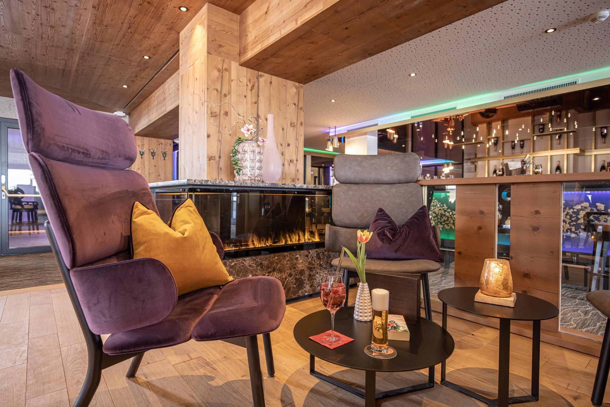 A stylish lounge area with modern armchairs and an elegant table. The warm wood and color accents create a cozy atmosphere.