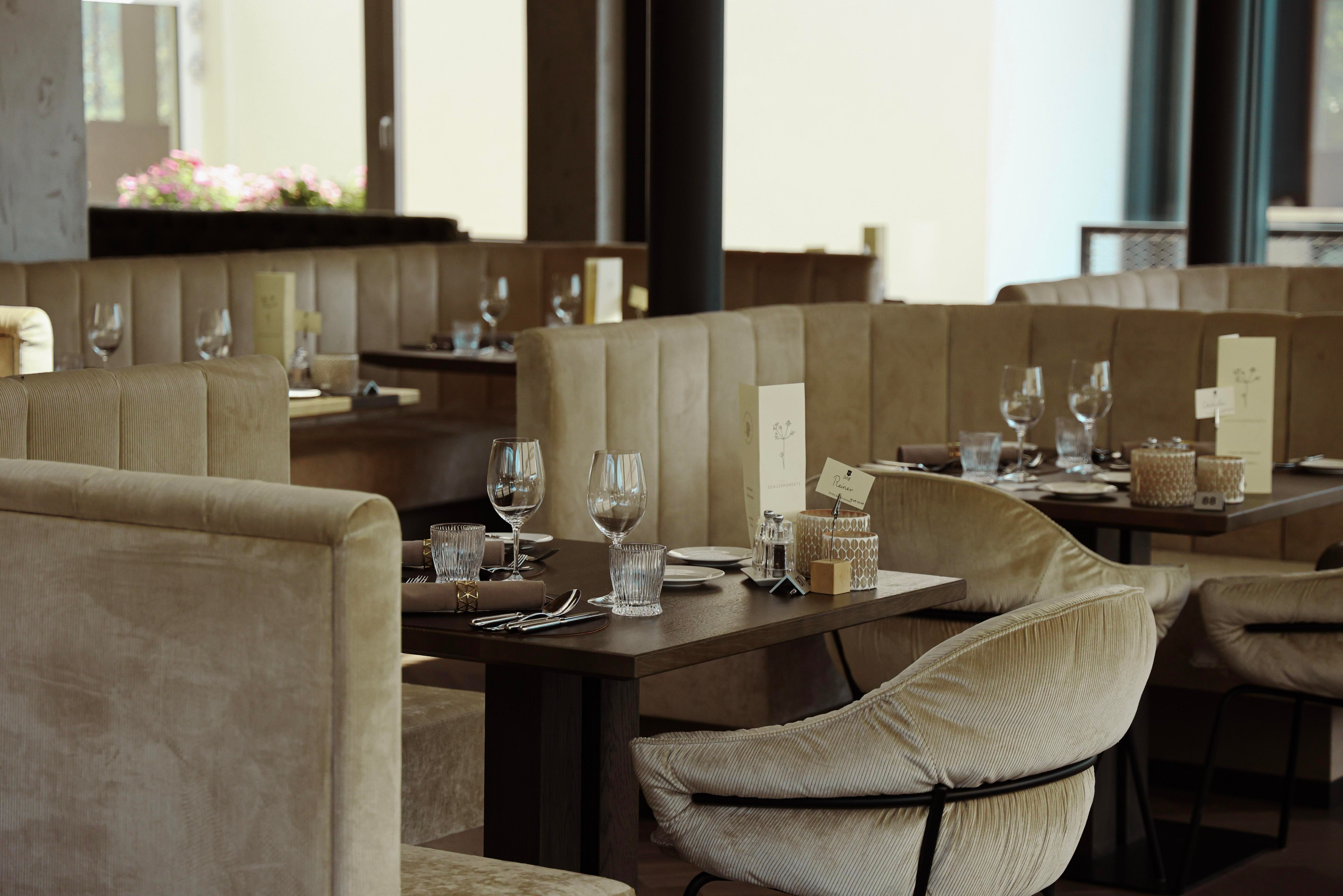 An elegant restaurant with comfortable seating and set tables. The atmosphere is modern and inviting.
