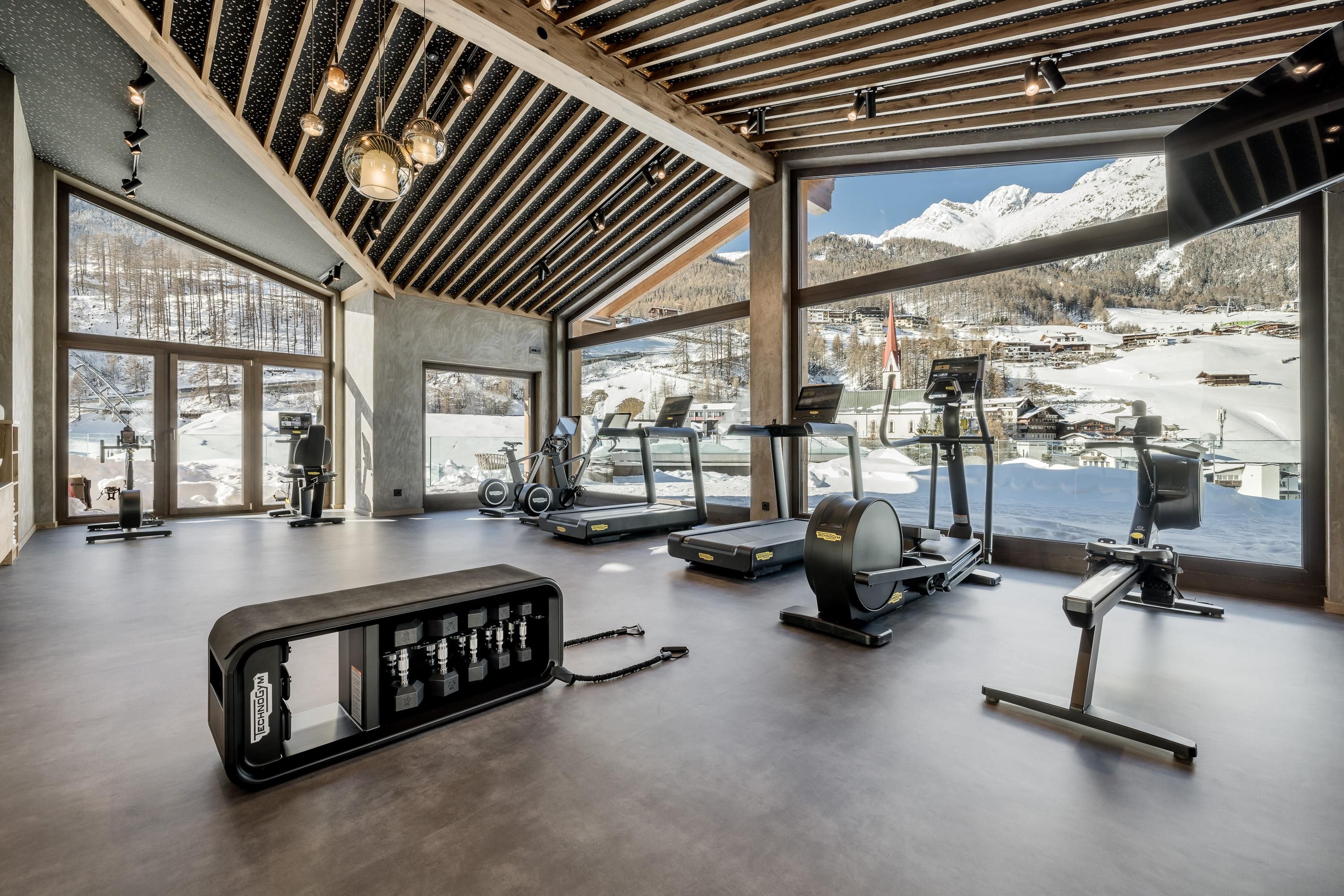 A modern gym with a view of the mountains. The large windows let in plenty of light and showcase an impressive view.