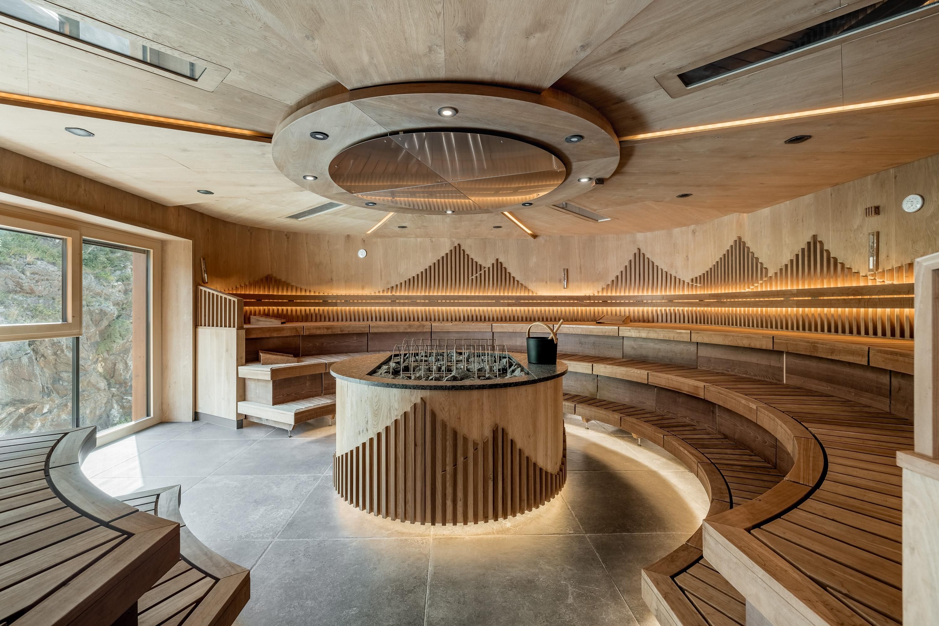 A modern and stylish spa with wooden paneling and soft lighting. The space offers a cozy atmosphere with seating and a central reception desk.