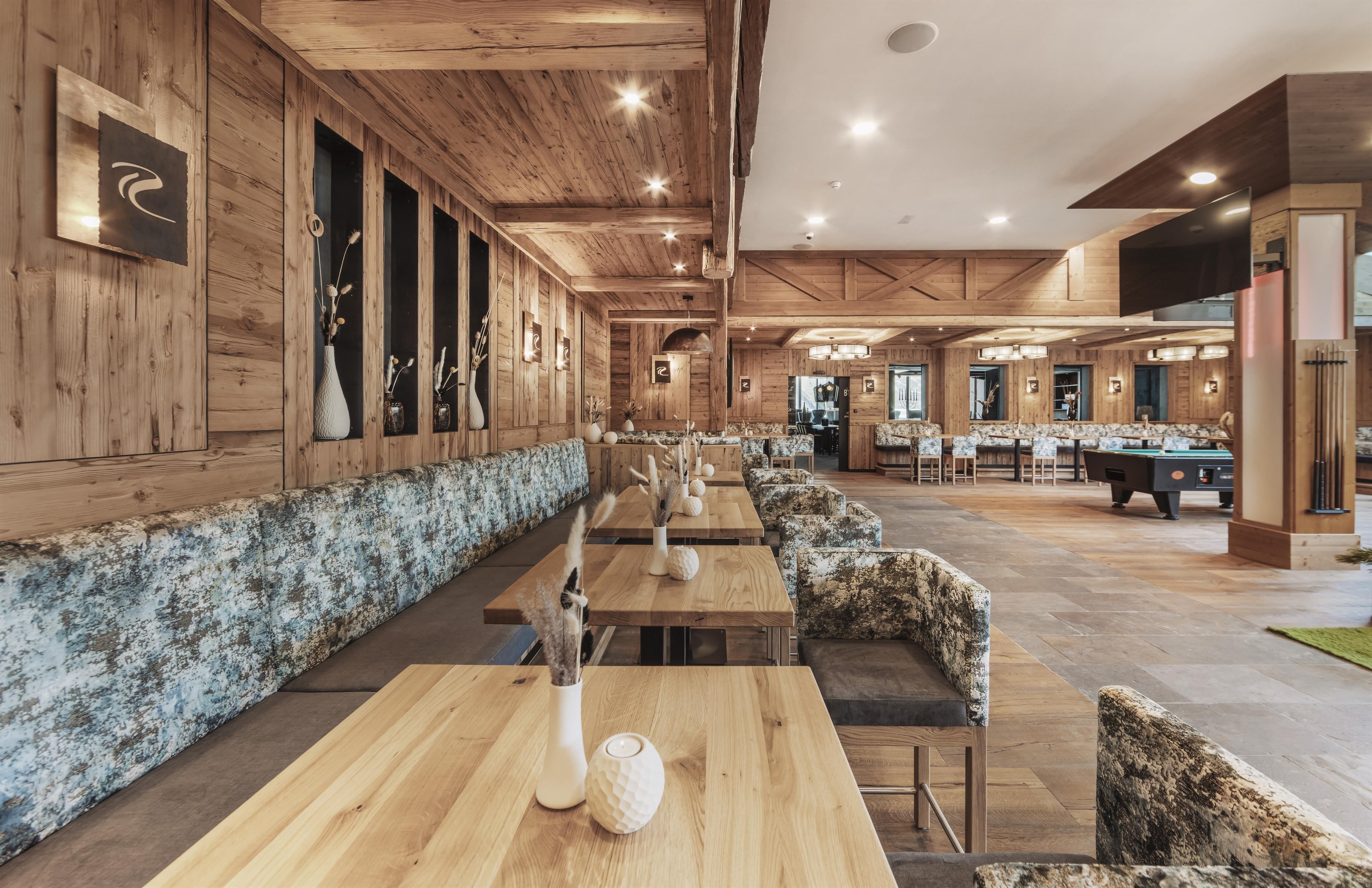 An elegant interior with wood paneling and cozy seating areas. The tables are neatly set, and there is a relaxed atmosphere.