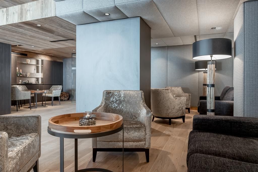 A stylish lounge ambiance with cozy armchairs and a round table. The lighting creates an inviting atmosphere.