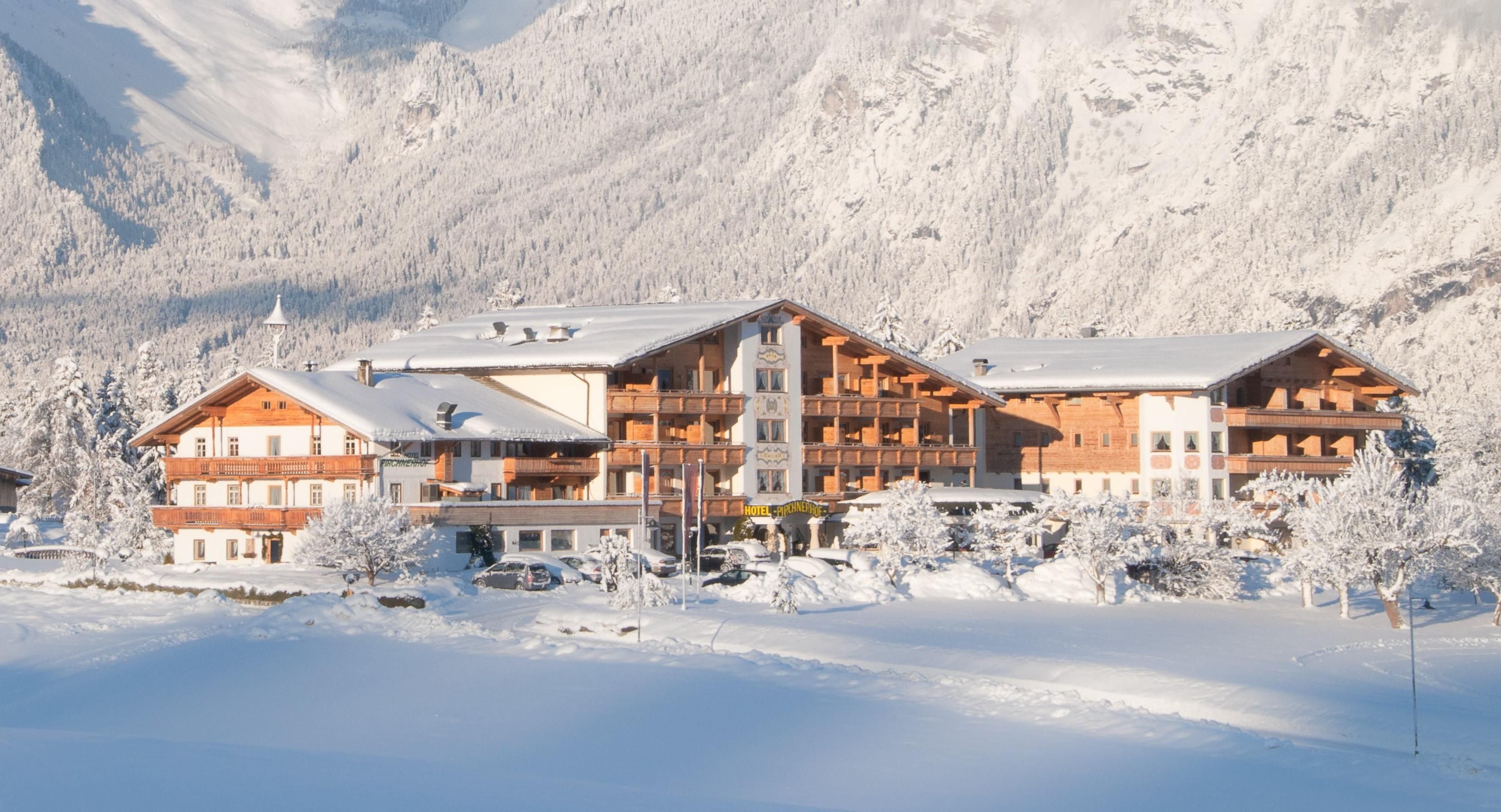 A picturesque hotel in a snowy landscape. The buildings are surrounded by snow-covered trees and exude tranquility and coziness.